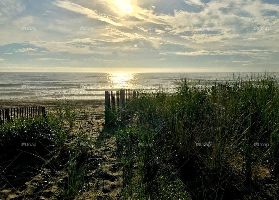 Footprints over the dune to a beautiful sunrise. 