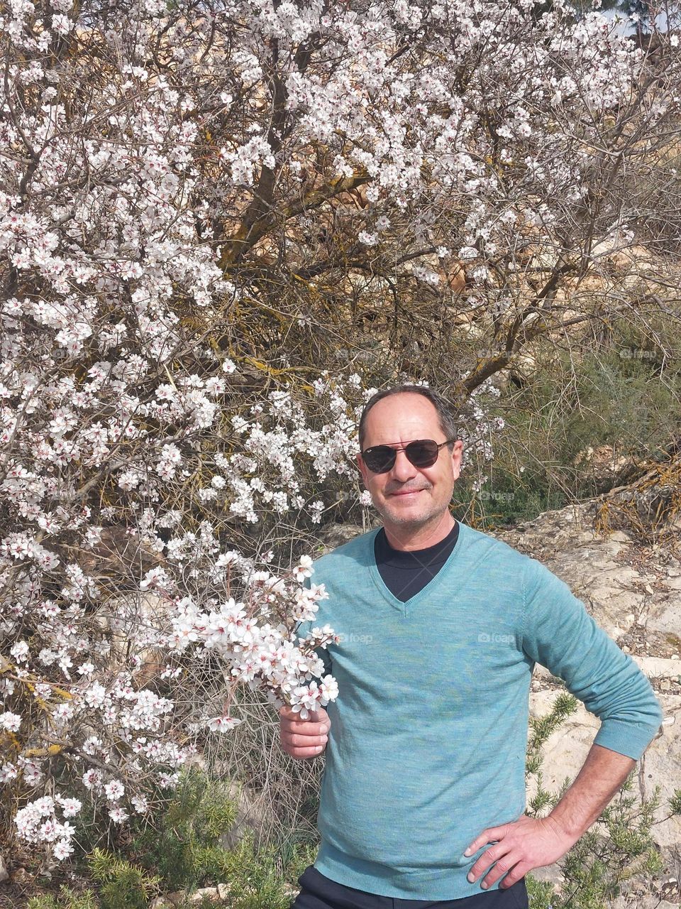 Hombre feliz con flores de almendro