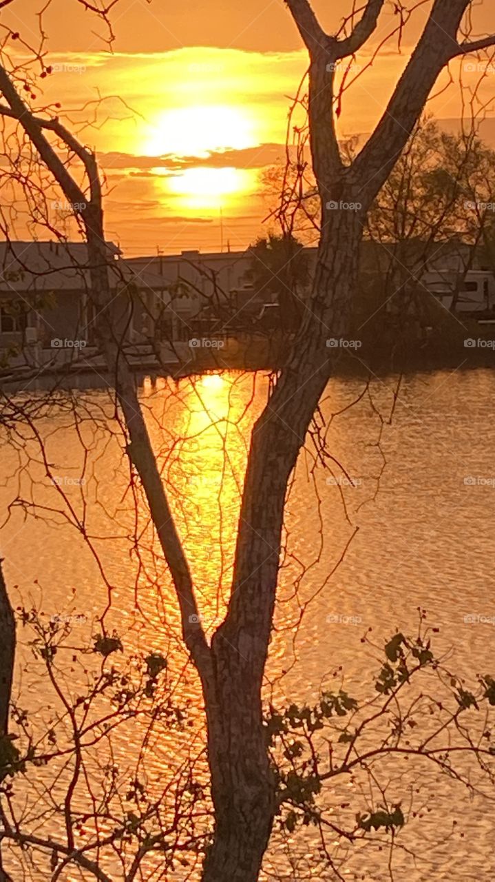 Sundown completed twilight in effect winding down bright colors of yellow sunbeams all add to the lasting Beauty of this photo not to mention the reflections of the colors on Lake Waters.
