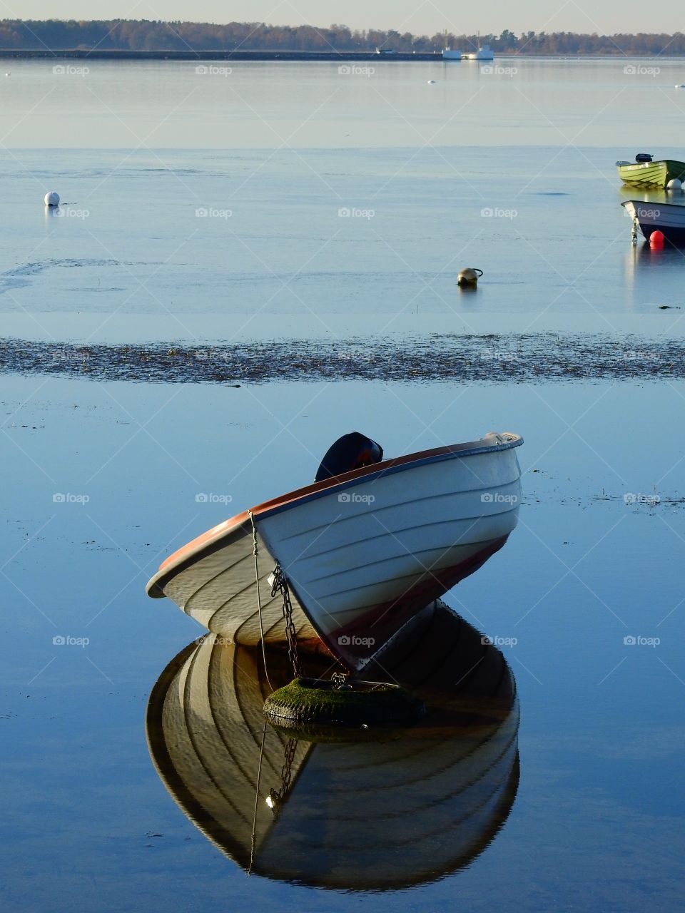 Reflection of boat moored on lake