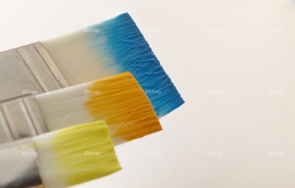 Paint brushes and paint blue yellow orange 