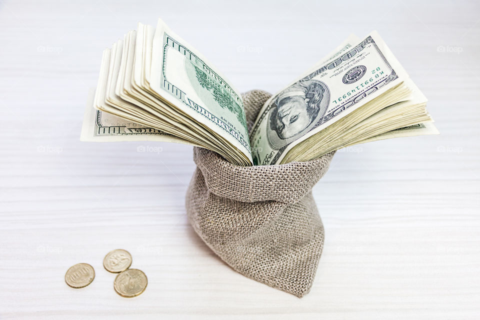 dollars in a linen bag and coins