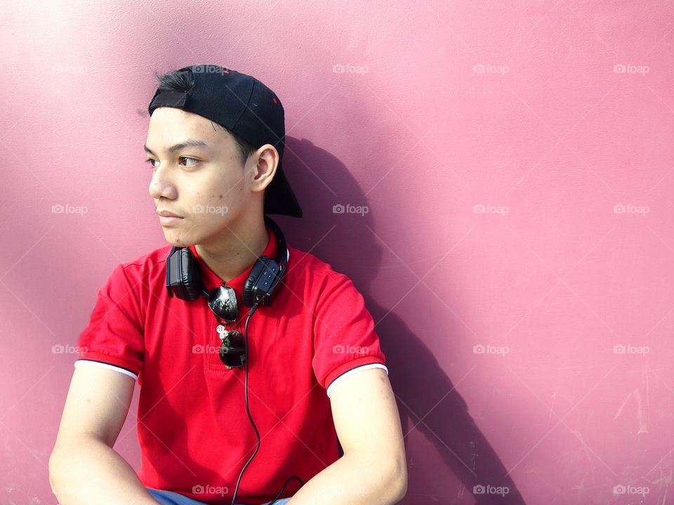 young teenage boy with cap, backpack, sunglasses and earphones