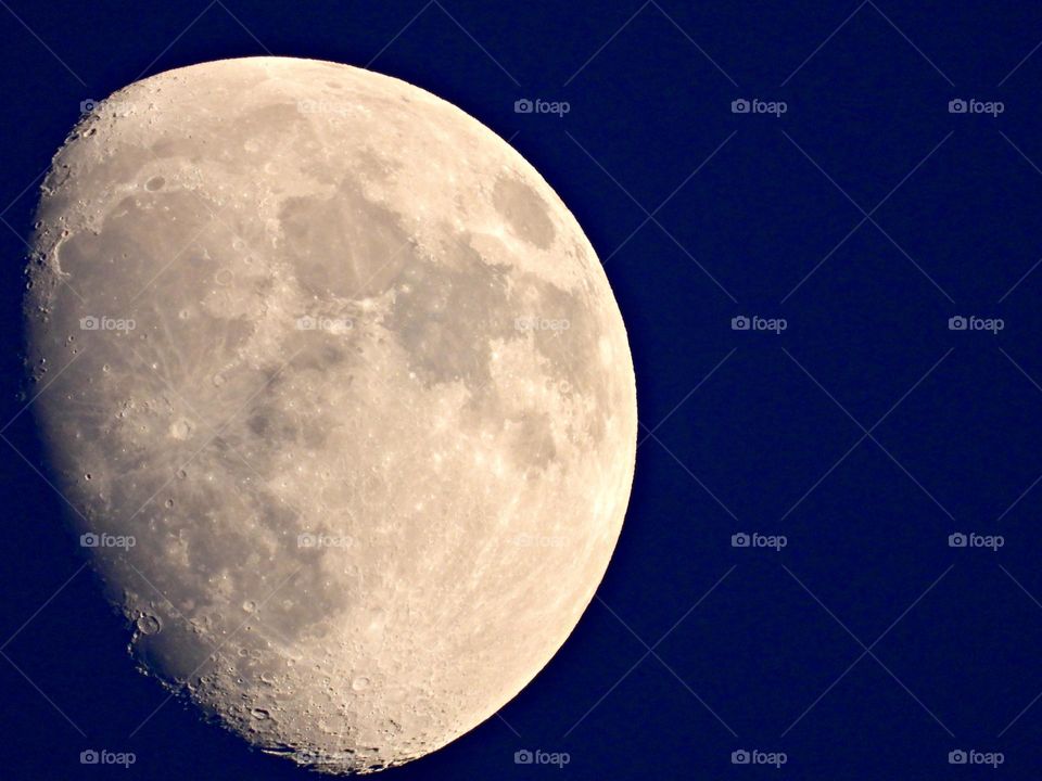 A waxing gibbous moon is in the sky when darkness falls. It lights up the early evening. It appears more than half lighted, but less than full. A waxing gibbous moon comes between first quarter moon and full moon.