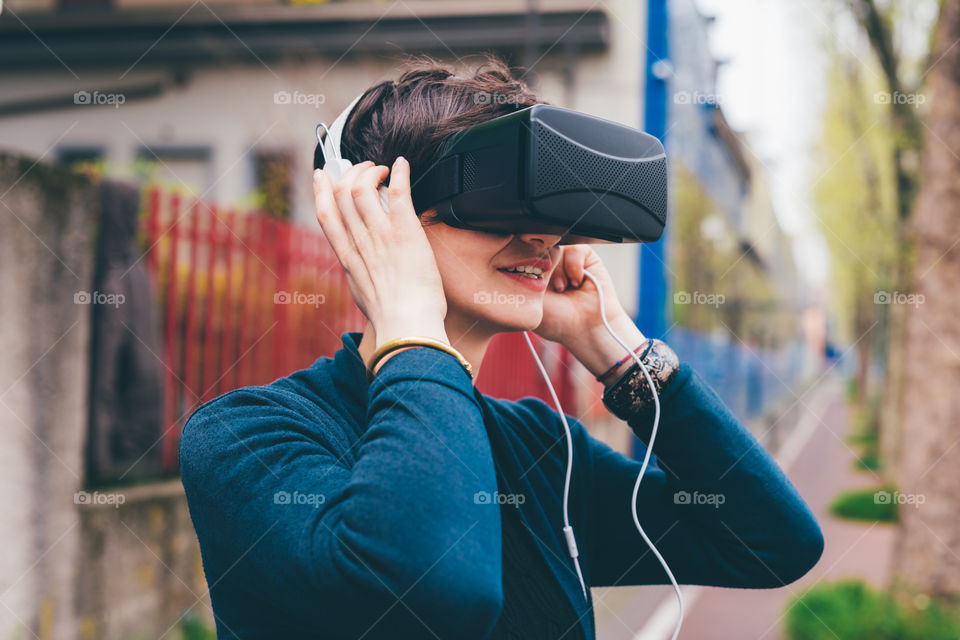 young beautiful woman using virtual reality viewer in the street - connection, virtual reality, technology