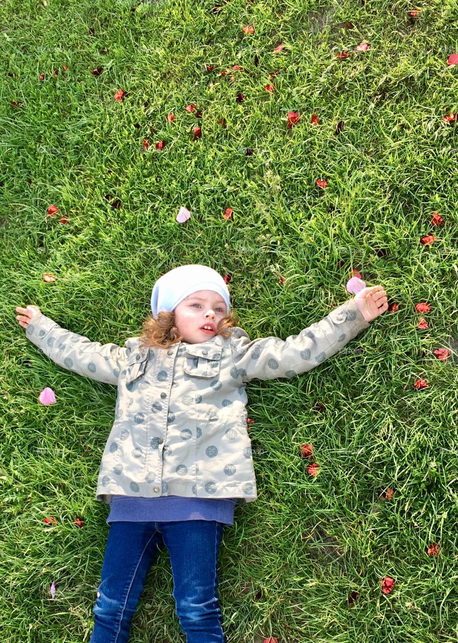 Funny cute girl lying on the grass 