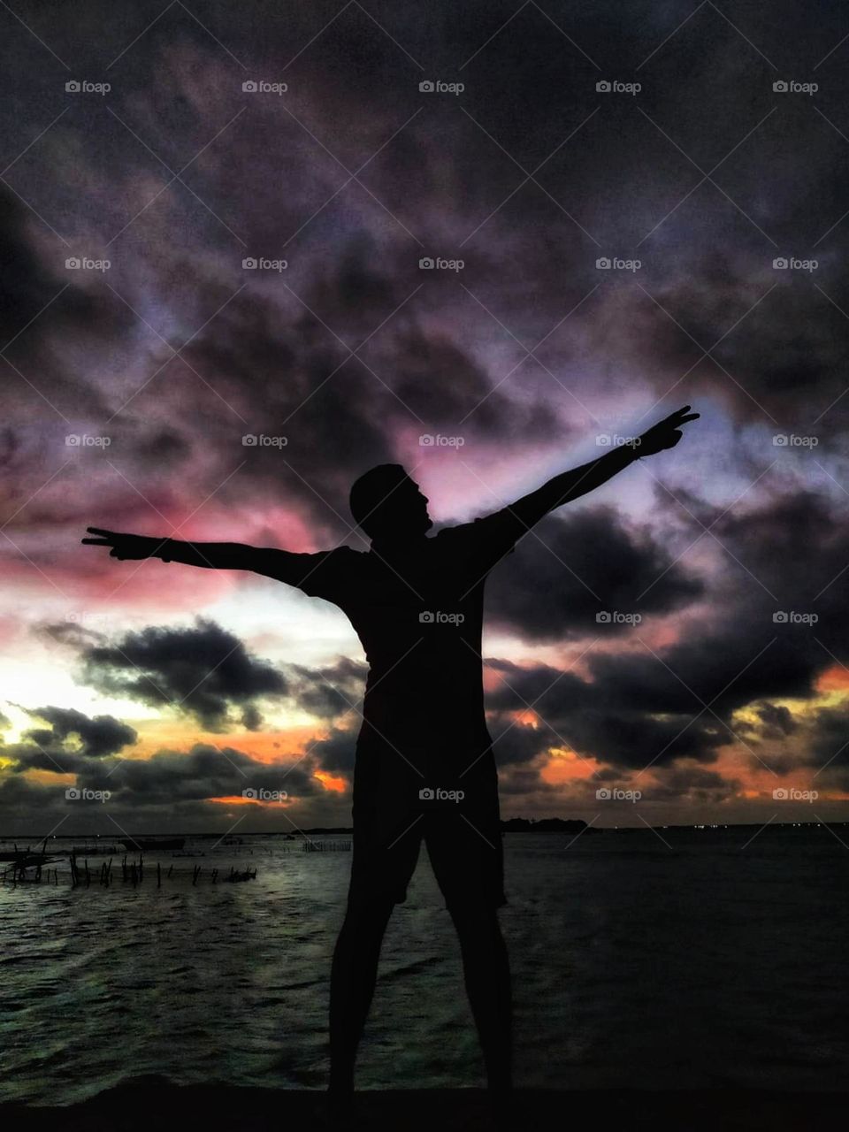 A boy in the sea side / evening dark / beautiful colourful sky / water / Sri lanka / Full of clouds