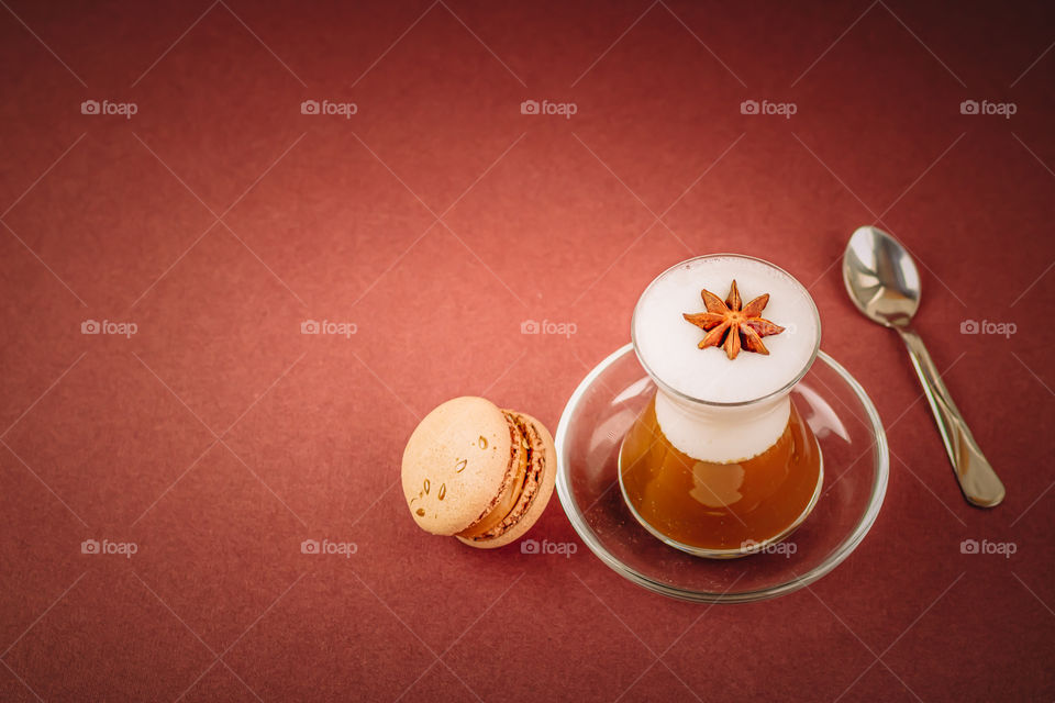 Cup with coffee and macarons on brown background with copy paste.