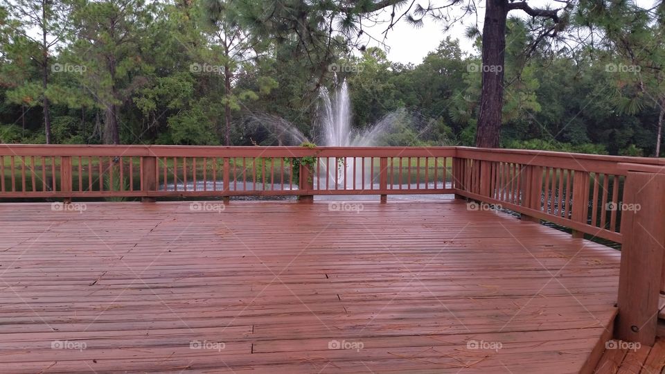 wooden deck with a fountain in the background