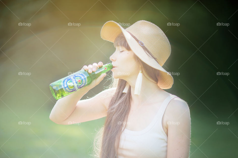 Beautiful young woman with bottle of nonalcoholic Heineken beer 