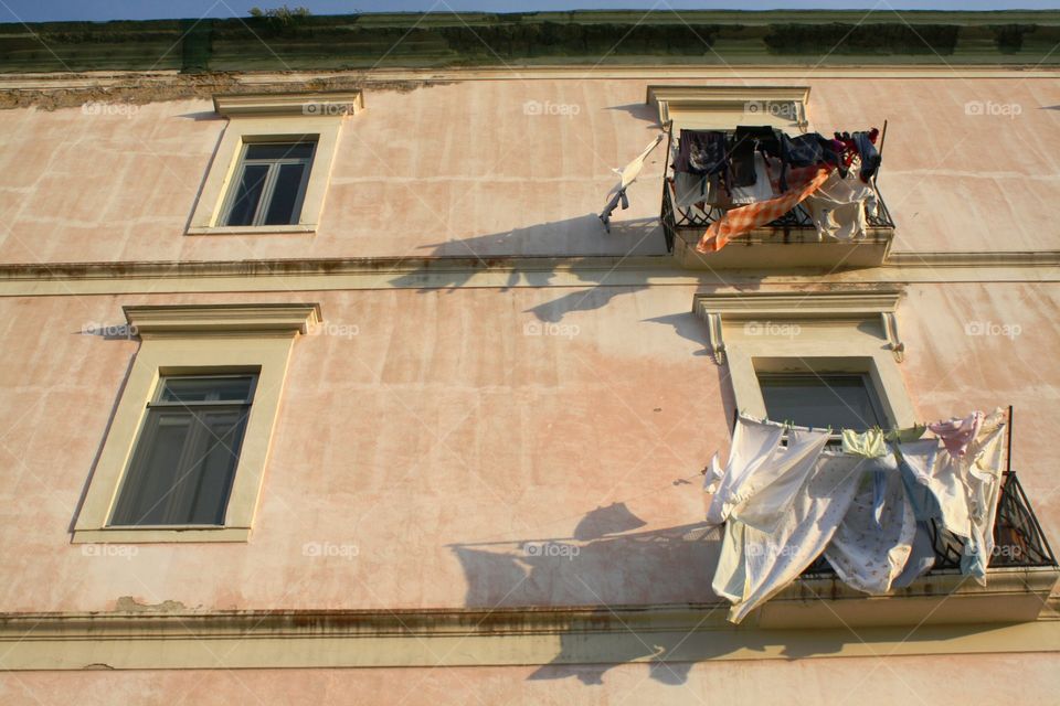 Drying laundry on facade under sun and wind