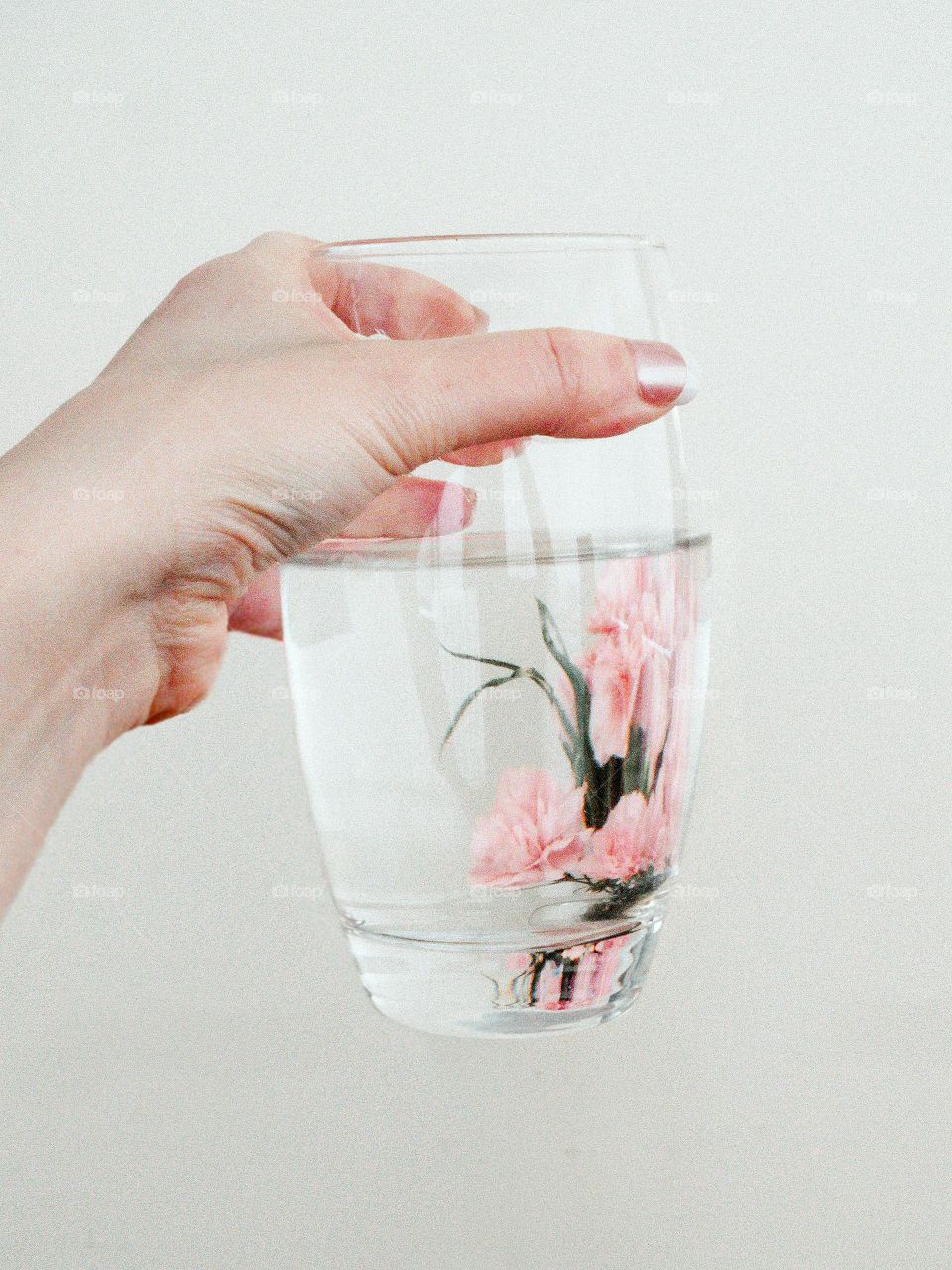 A glass of water with natural flowers in it