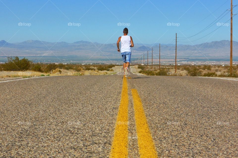 Rear view of men running on road