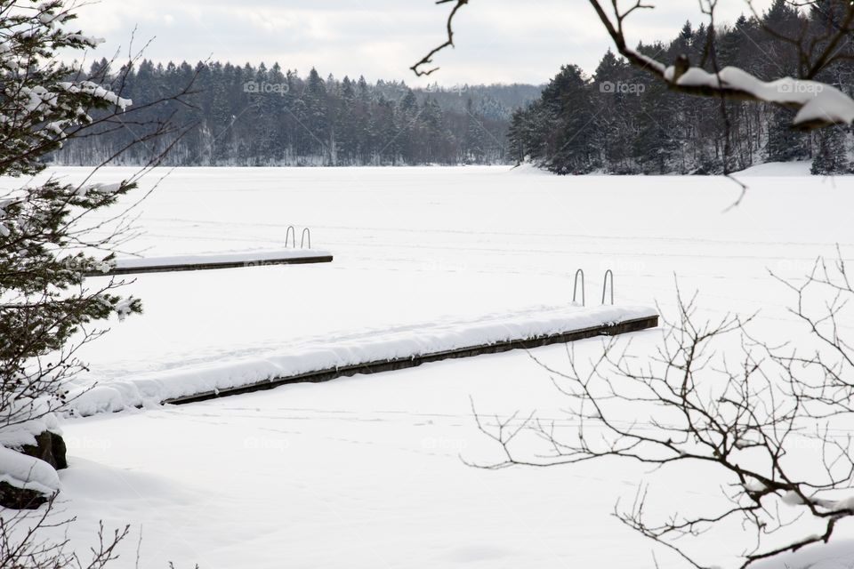 Longing for summer. Beach and jetty in snow. Sweden - längtar efter sommar. Badplats med bryggor i snö, kåsjön Partille , Sverige 