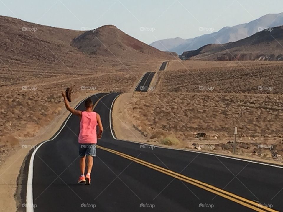 Man walks on a desolated road in the Desert 