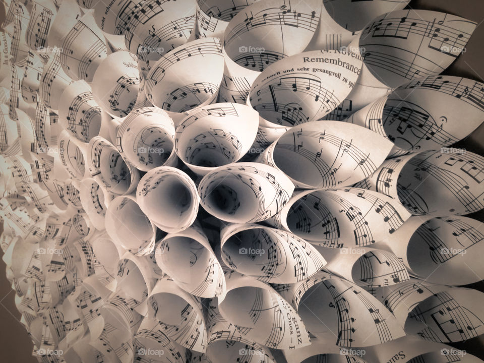 music sheets rolled into pointed cones in a flowery array