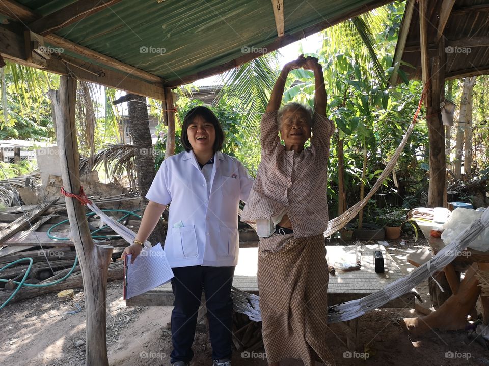 Physical therapist and the elderly're standing with smile.