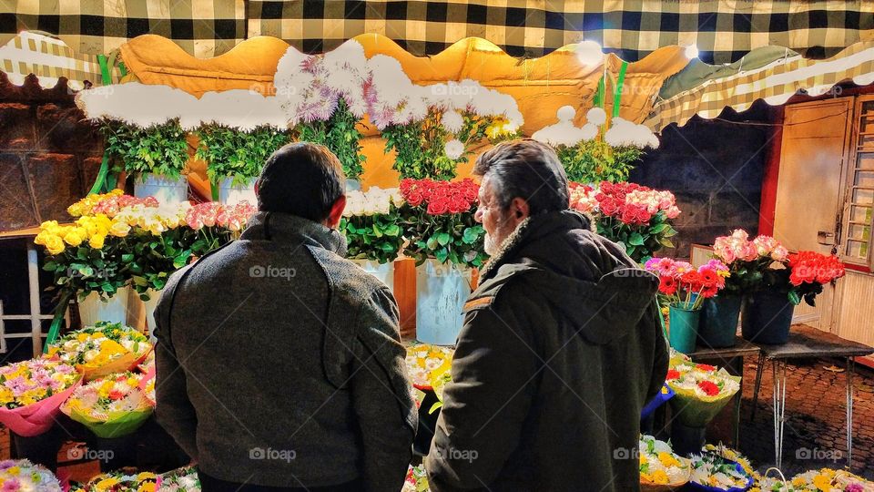 Noticed those two men while they were discussing which flowers to get.