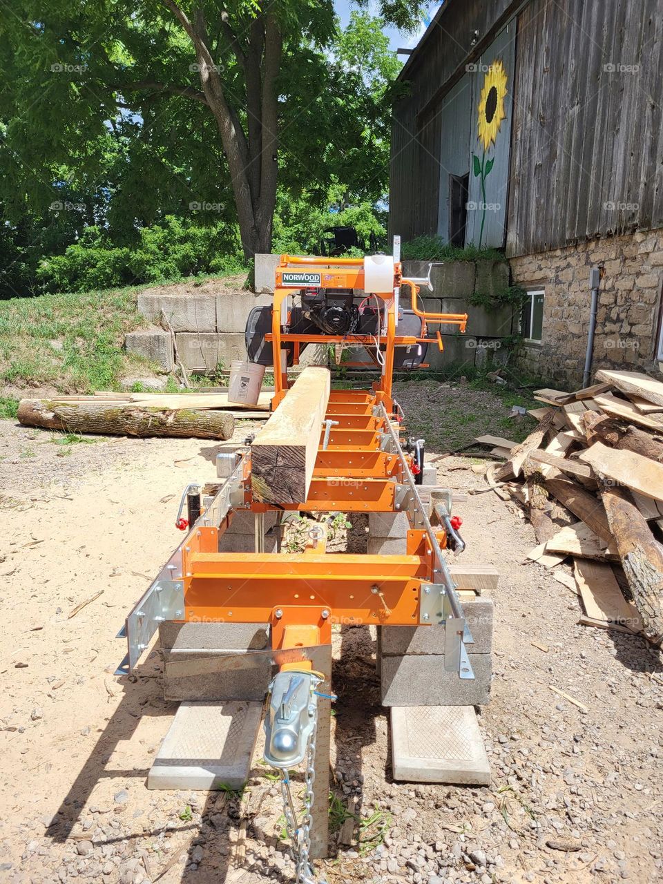 Sawmill with cut timber in front of barn