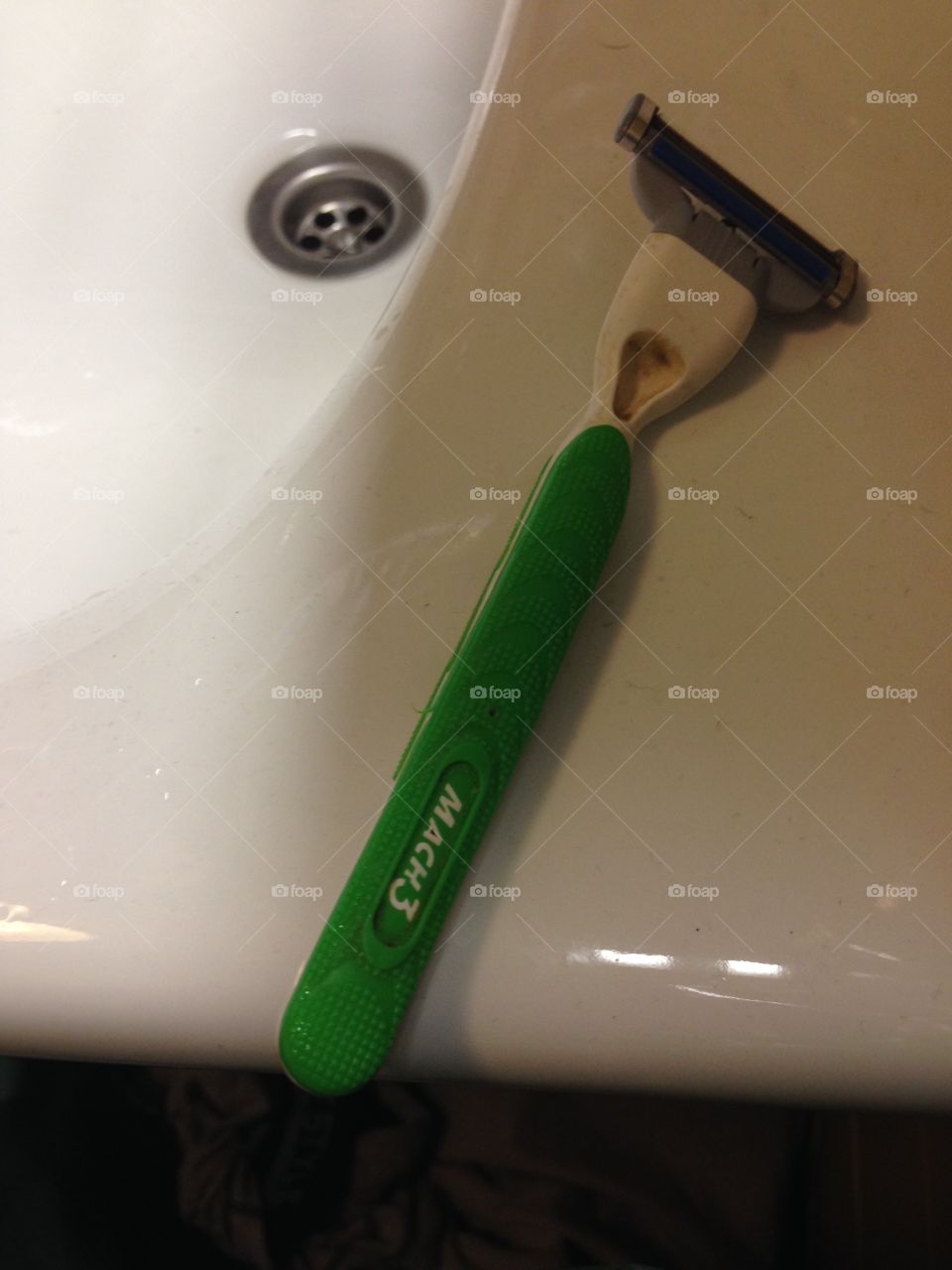 Razor at the side of the sink, ready for the daily shaving ritual.