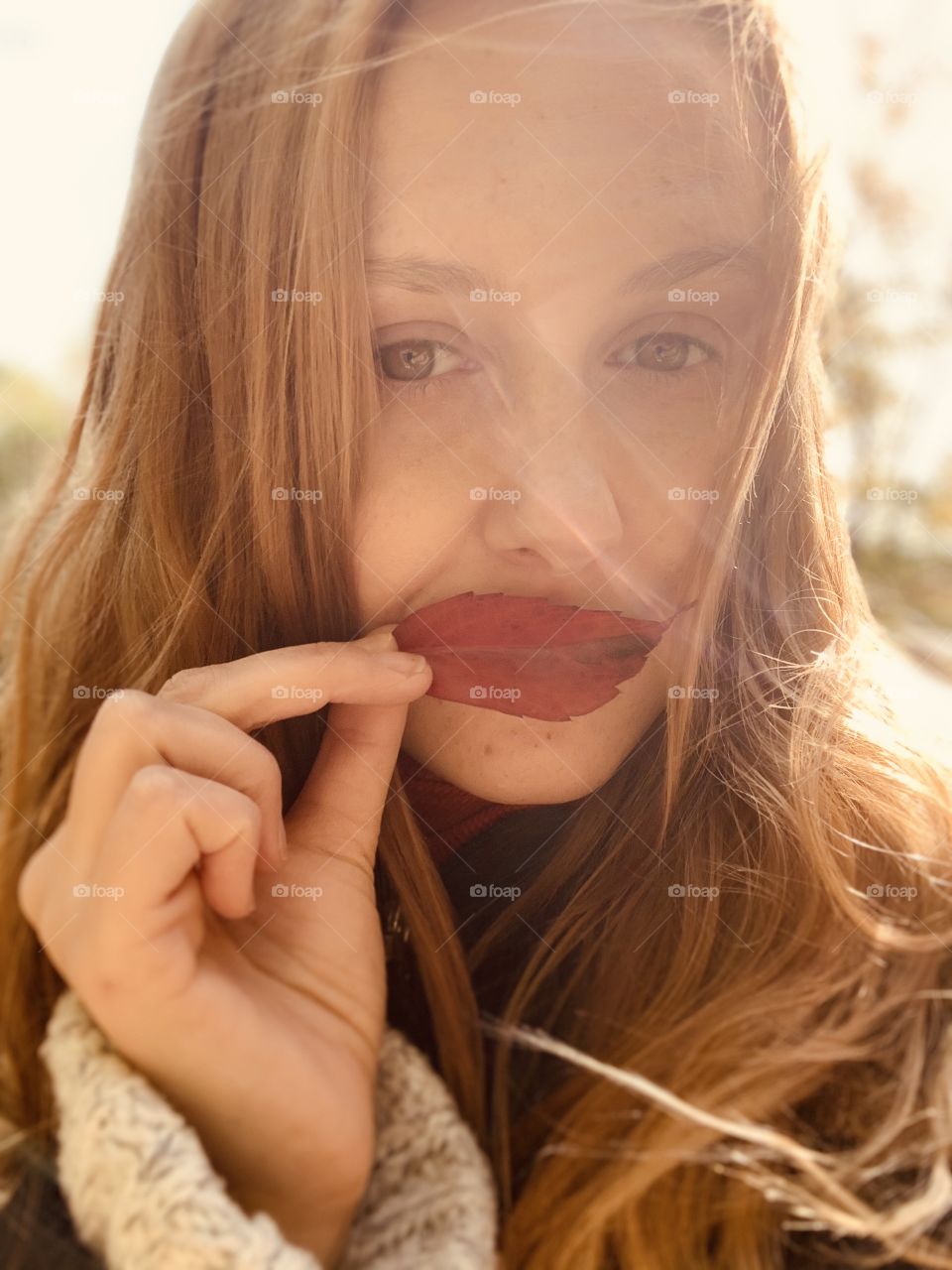 iPhone warm sunny selfie portrait with red leaf 