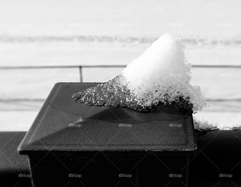 Snow melting on the back deck railing 