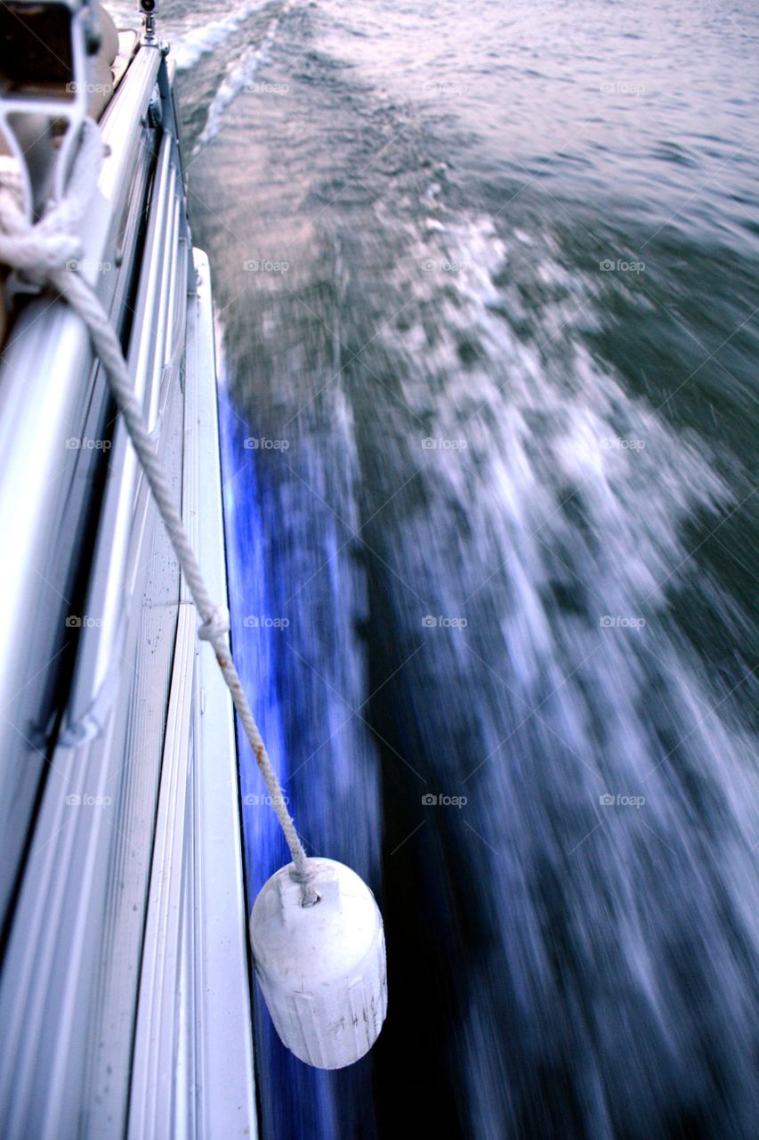 Low angle view of side of boat speeding through water creating wake