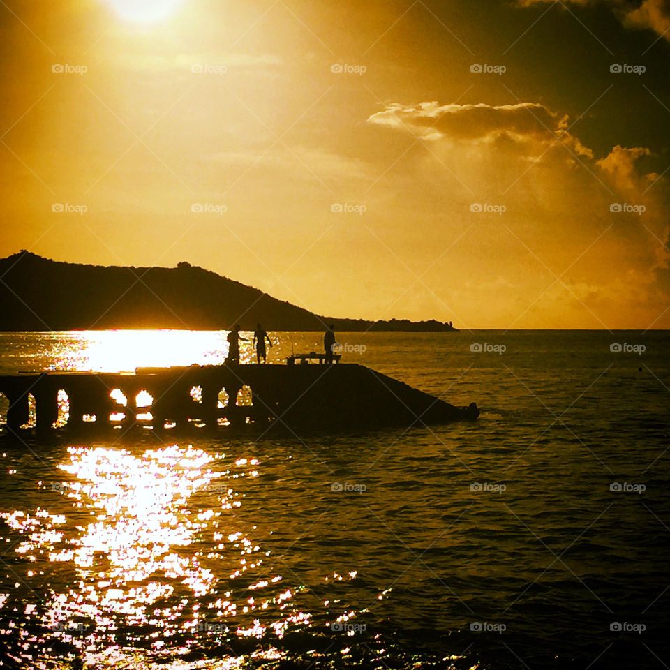 In the shadows, backlighting on a pier, pier stretched into the water, Caribbean island sunsets 