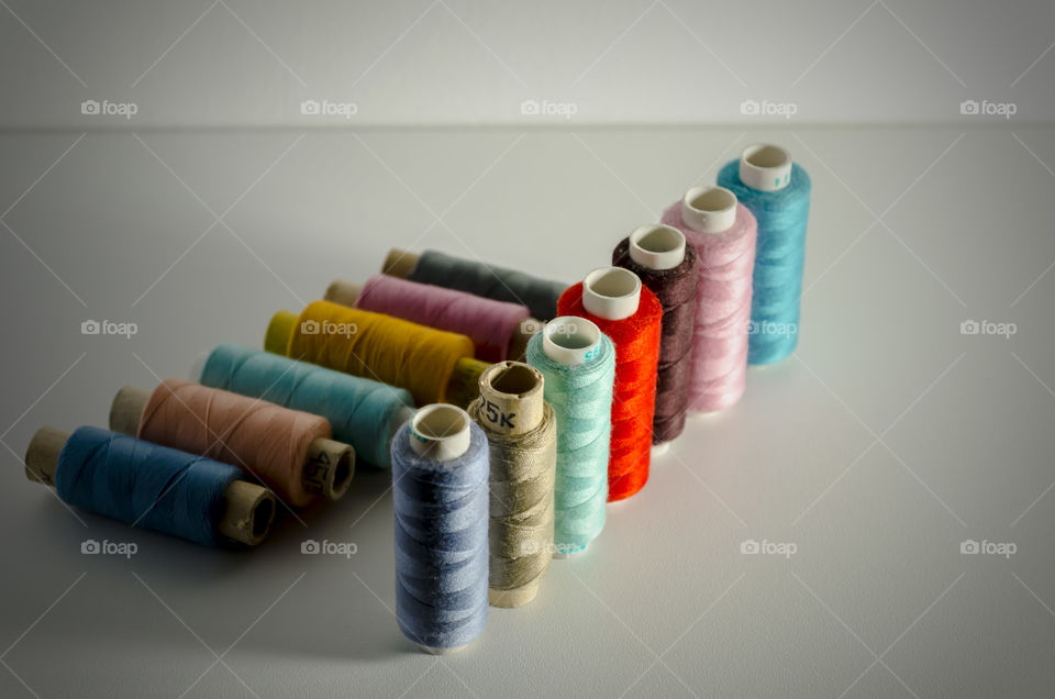 colored thread spool sewing equipment on a white background