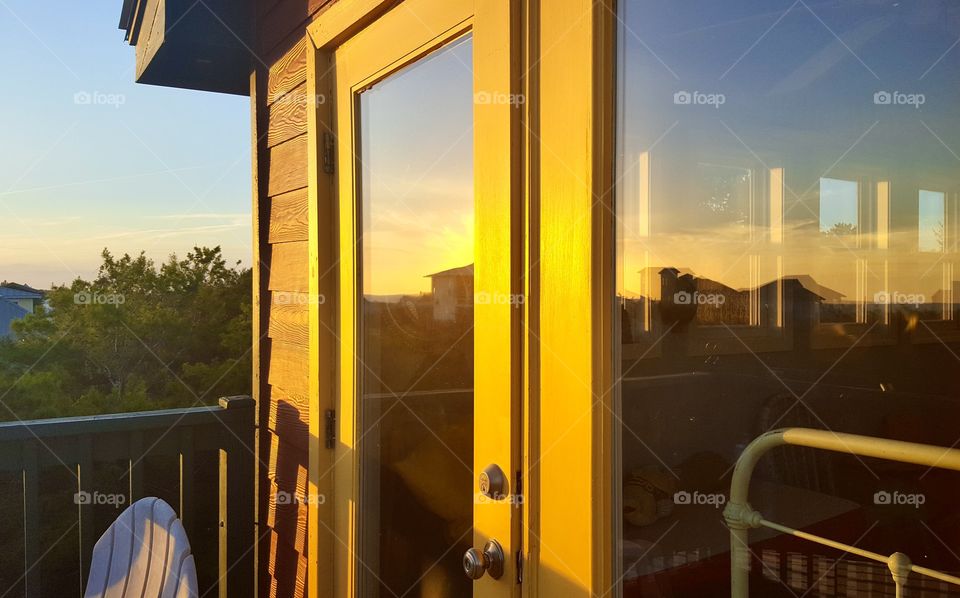 Bright sunlit yellow door to crow’s nest at beach house