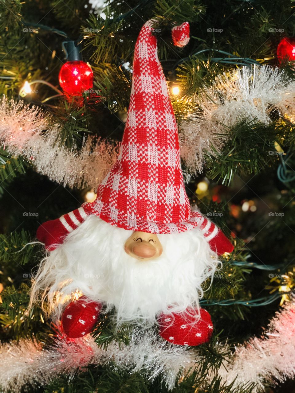 A plump gnome makes himself at home in my red and white “gnome sweet gnome” Christmas tree in Minnesota.