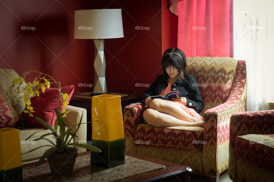 Asian girl reading book at home