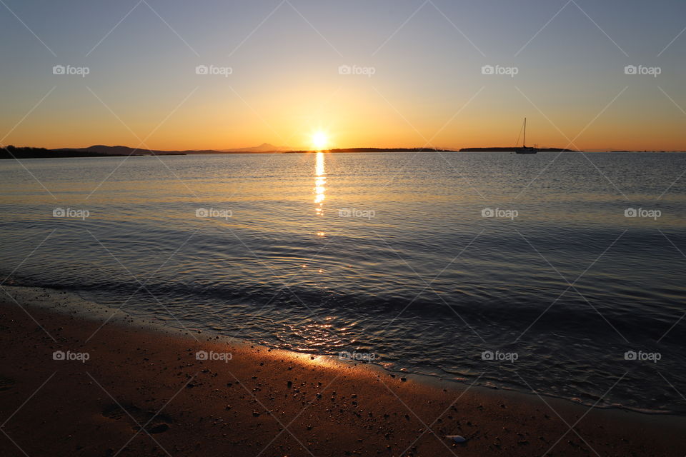 Sun rising above calm ocean 