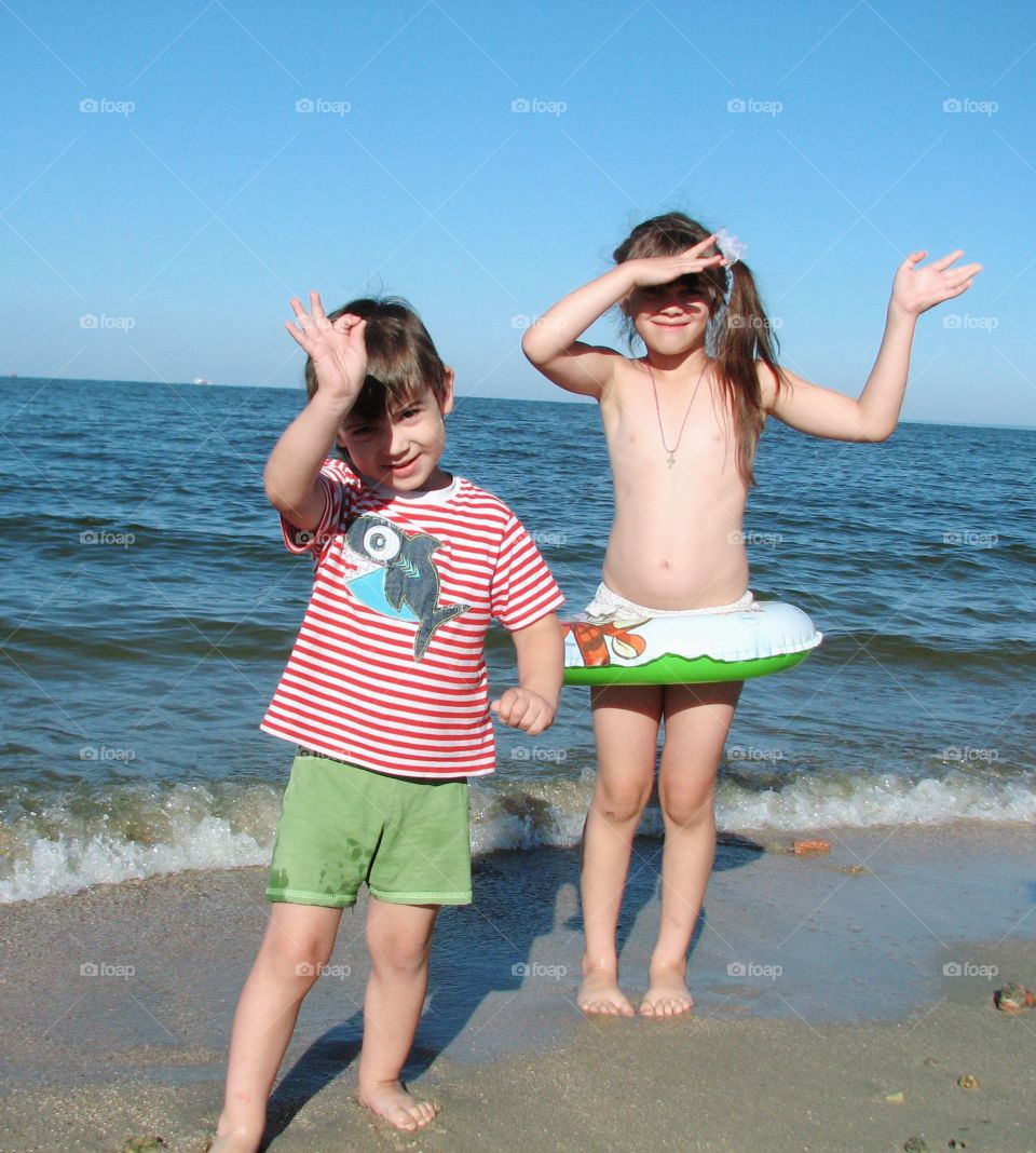 children stand on the shore