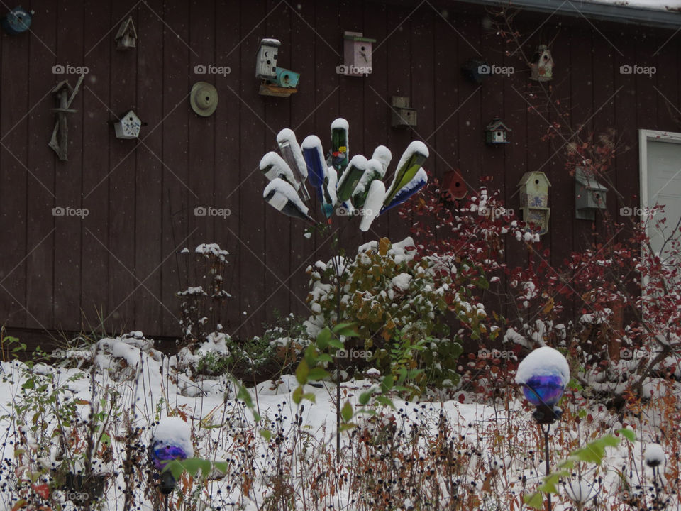Snow covered wine bottle sculpture and garden globes