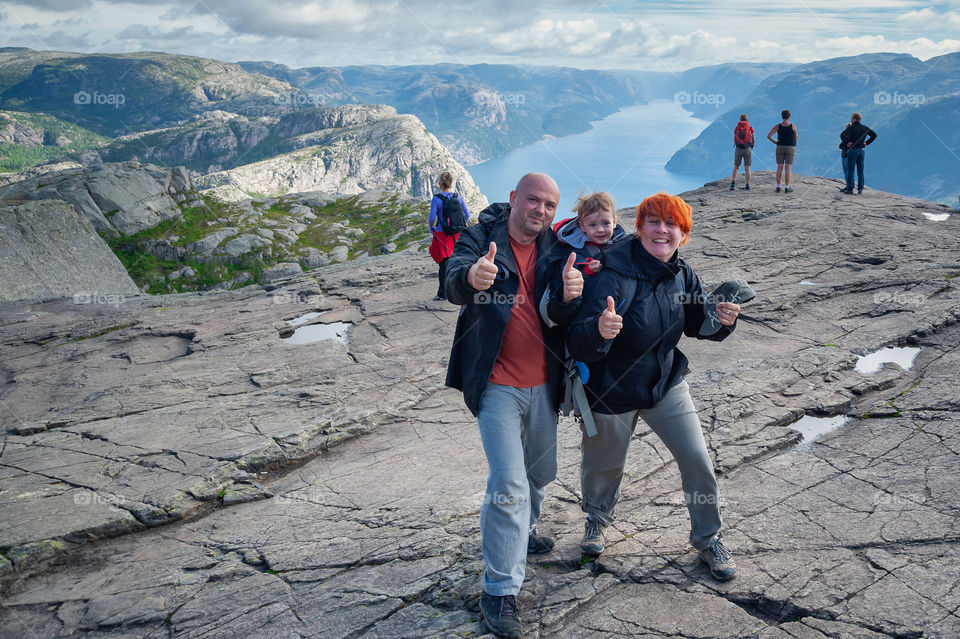 Thumbs-up. Mountain hike. Happy family on top of the Preikestolen or Pulpit Rock. Norway. Europe.