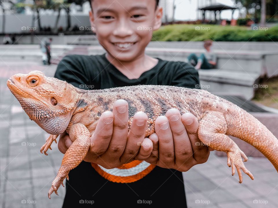 A boy holding a bearded dragon in  Kuala Lumpur, Malaysia