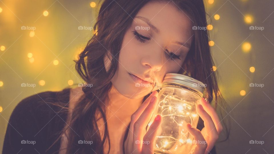 Young woman holding light jar in hand