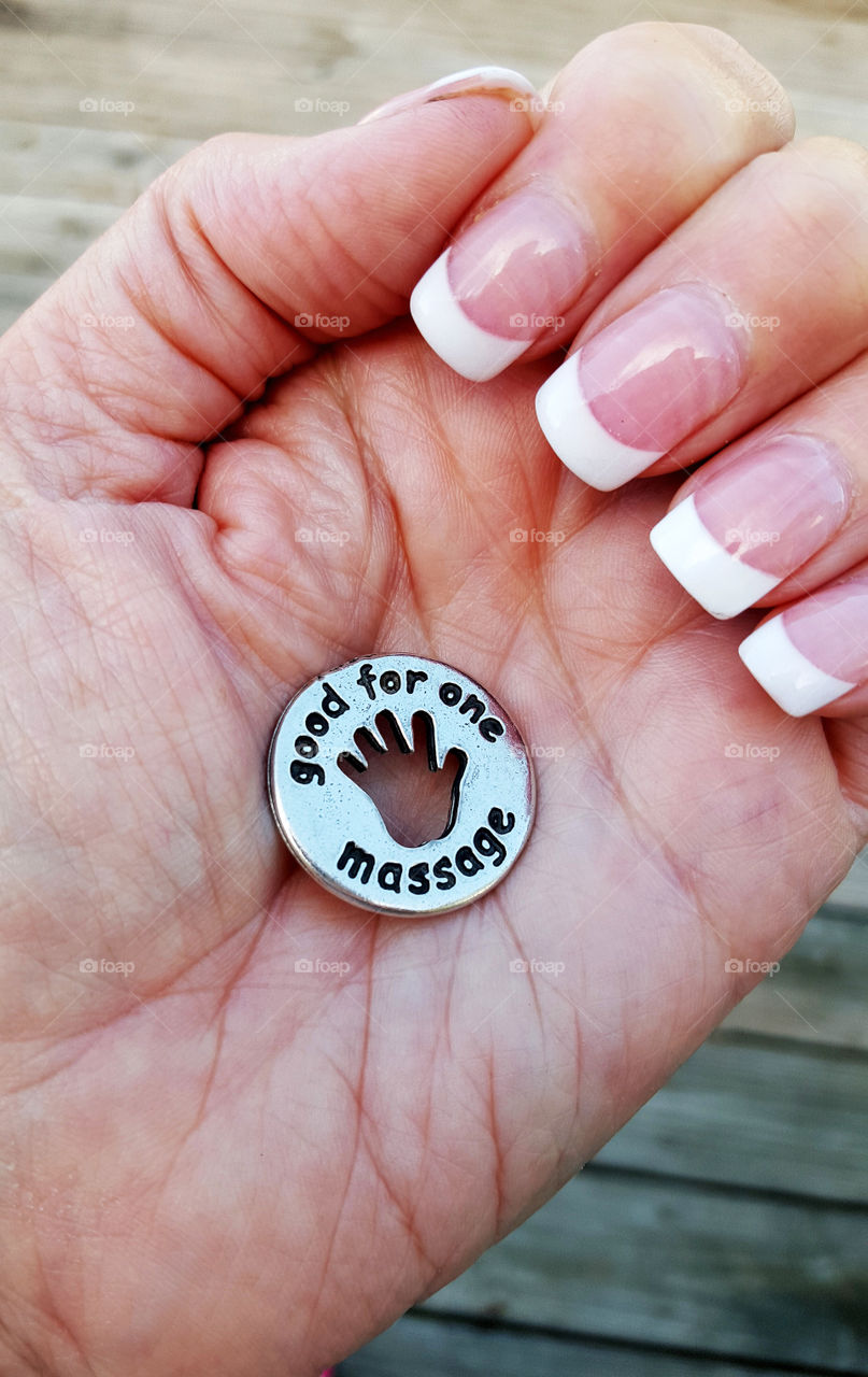 massage token. hand holding token good for one massage