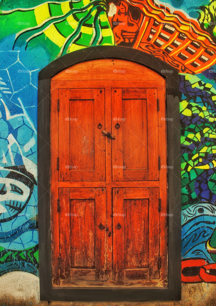 wooden door in a colorful wall...