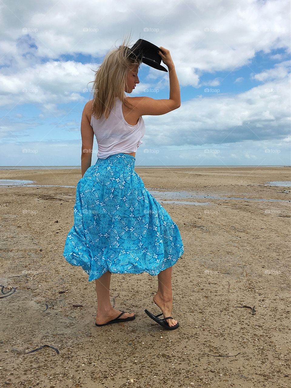 Beautiful woman in skirt holding hat