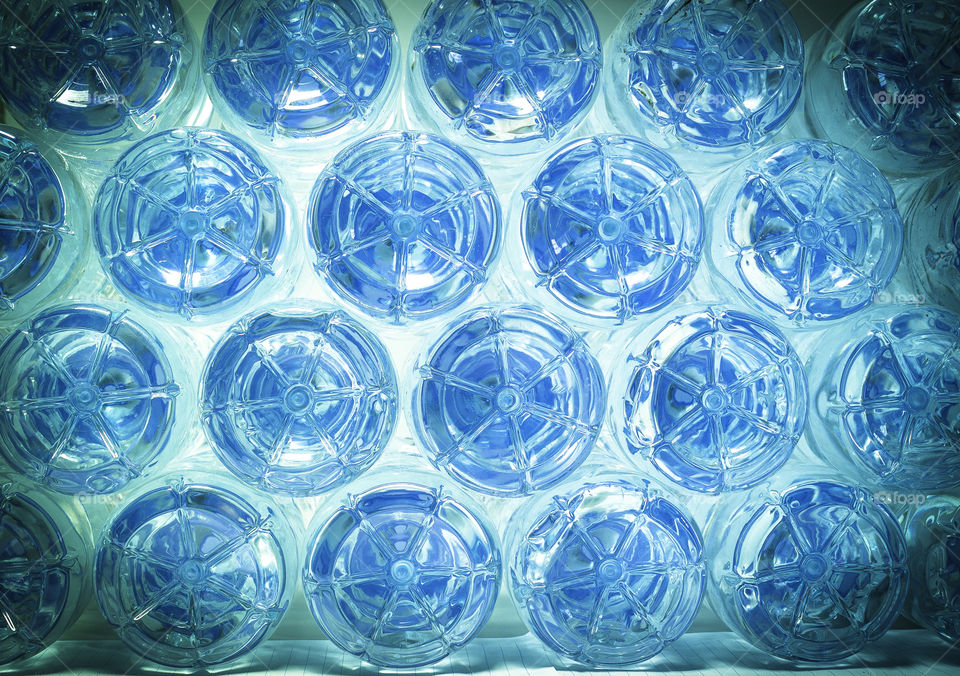 Row of water in plastic bottles bottom on blue background