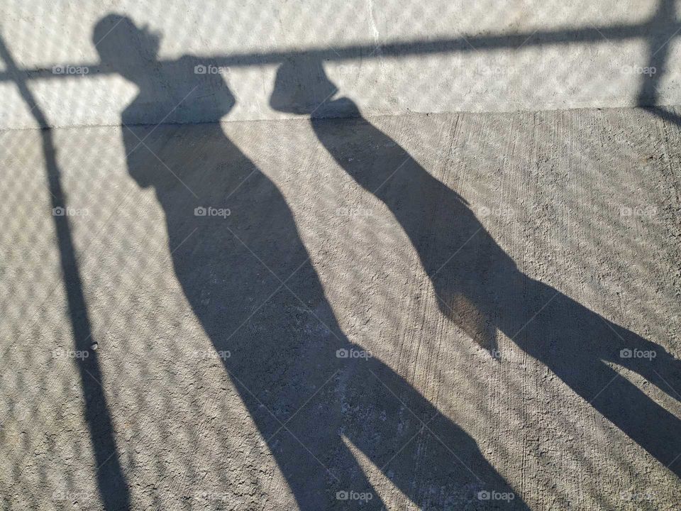 Long shadows of summer, adult and child walking and playing