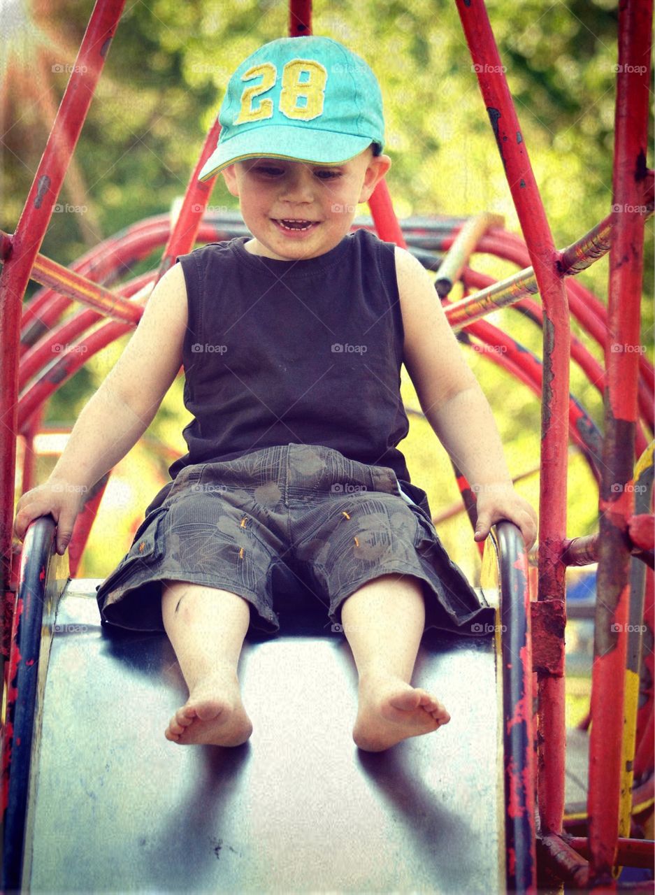 Sliding. A boy go down the slide