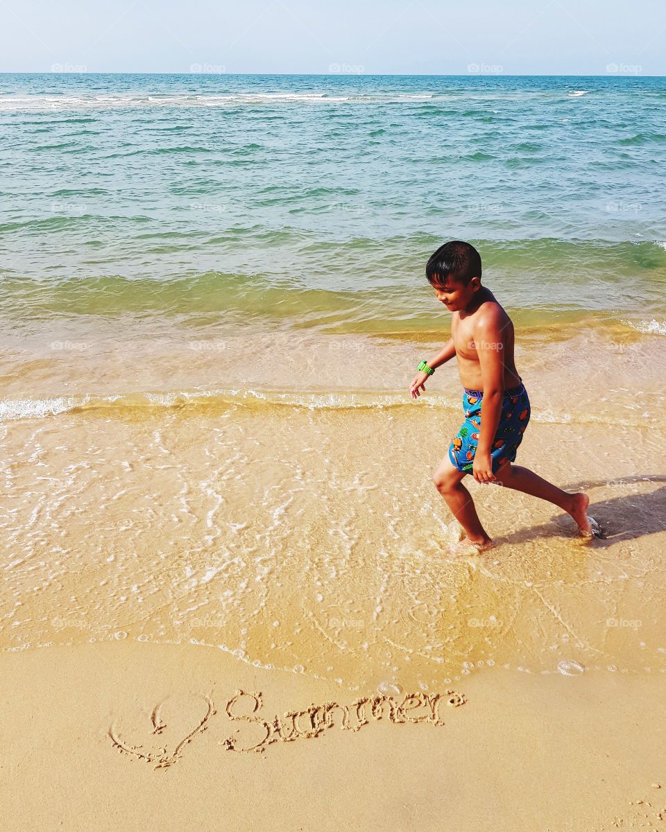 Kid playing on beach in summer