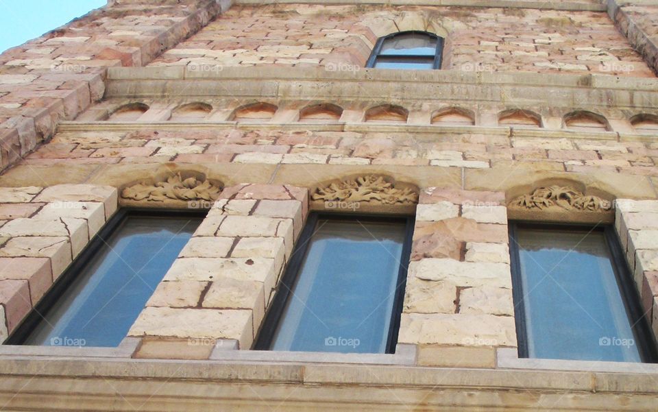 The wall of this building in the US showcases impressive architectural features including arched windows and carvings