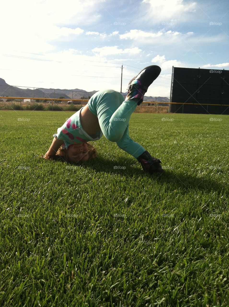 somersault. candid shot of her playing in the grass