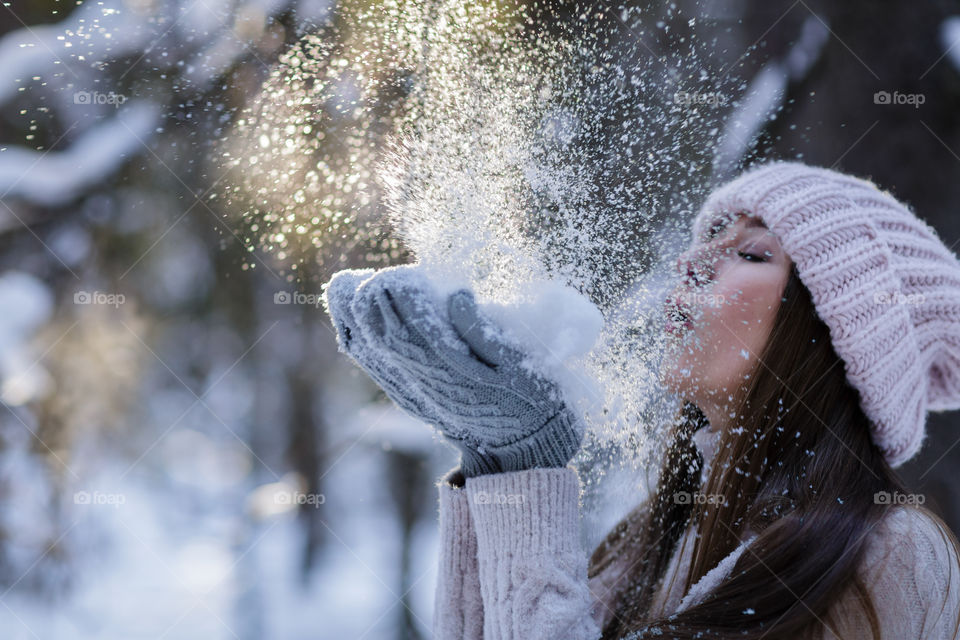 Woman blowing on snow