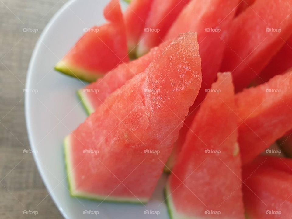 a close up portrait of slices of watermelon. the healthy fruit is ready to be eaten.