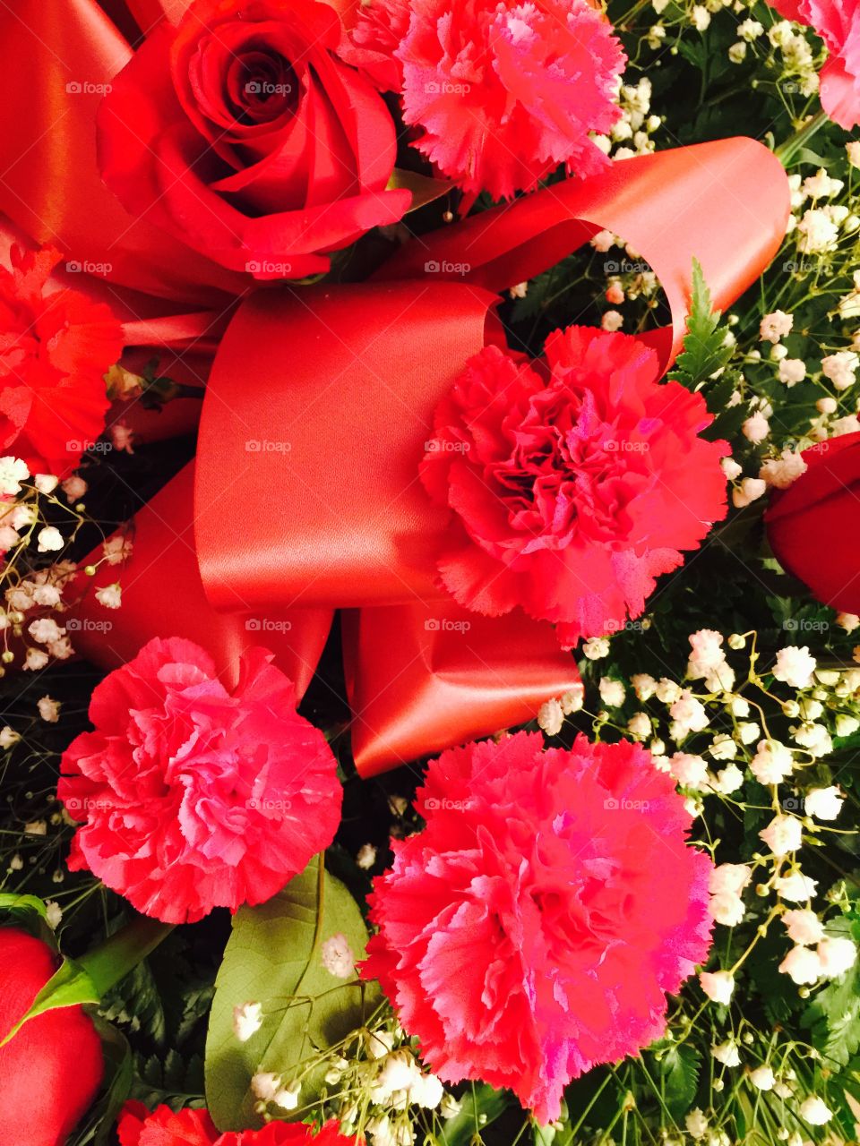 Red Floral Arrangement. Floral arrangement of red roses, red carnations and red ribbons